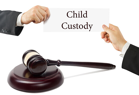 gavel between two hands holding up a sign that reads child custody