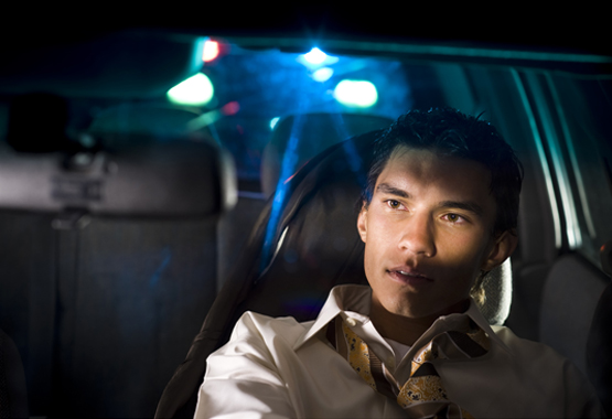 man behind the wheel of a car getting pulled over for a DUI