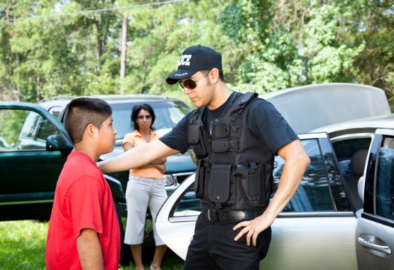 A police officer talking to a child after getting caught in a bad situation