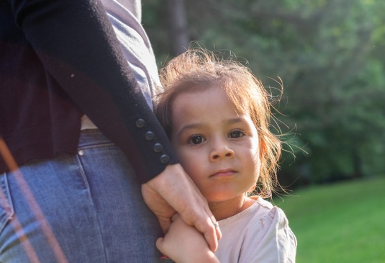 A young girl looking worried with their parent in Peoria IL