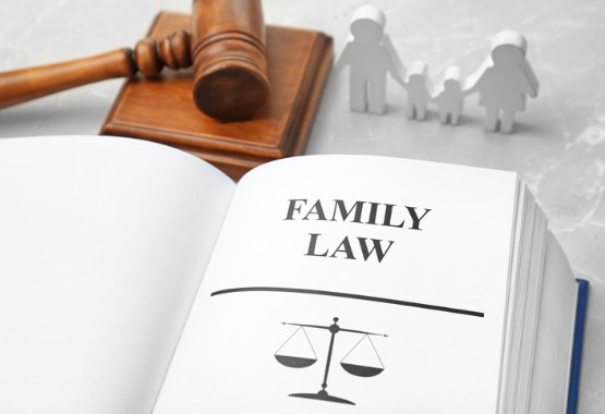 A law book, gavel and wood figures of a family, representing a family law attorney in Pekin IL