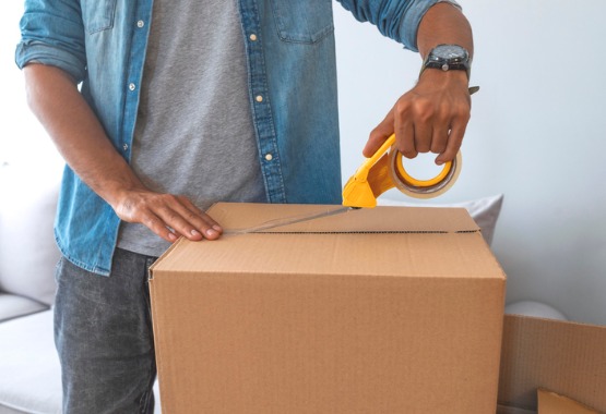 A man packing a box and moving out of a house after a divorce in Pekin IL