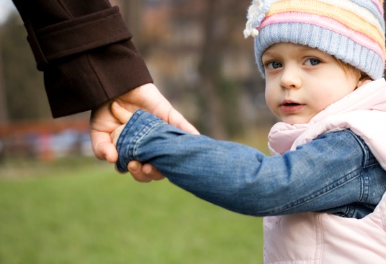 A mother holding the hand of her child after working with a Child Custody Lawyer in Pekin IL