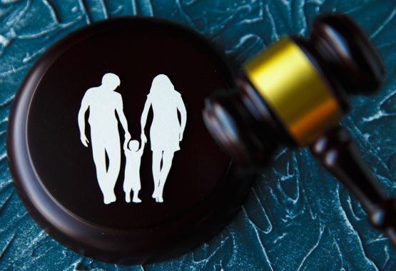 A paper family cutout on a gavel, representing child custody law and visitation rights in Illinois