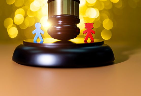 A gavel in between two wooden dolls of children, representing separation and child custody agreements in Illinois