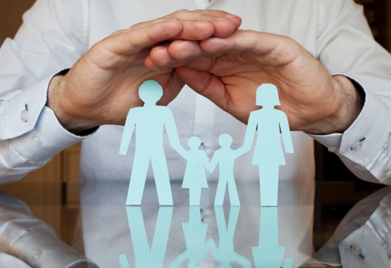 A Peoria DCFS lawyer holding his hands over a paper family, representing protection of families